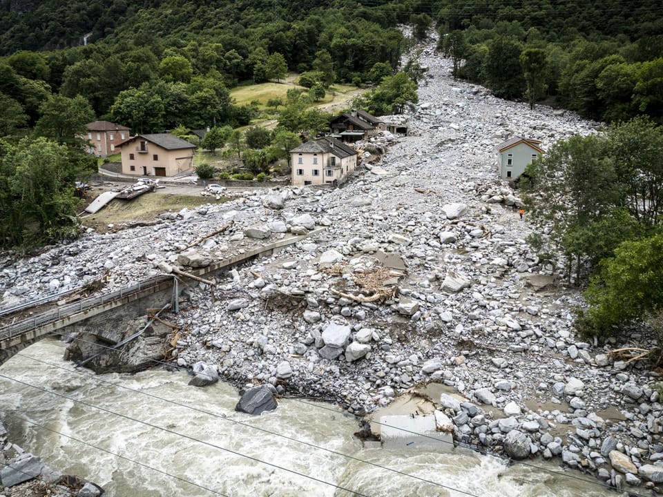 Überschwemmtes und von Geröll übersätes Dorf nach einem Erdrutsch.