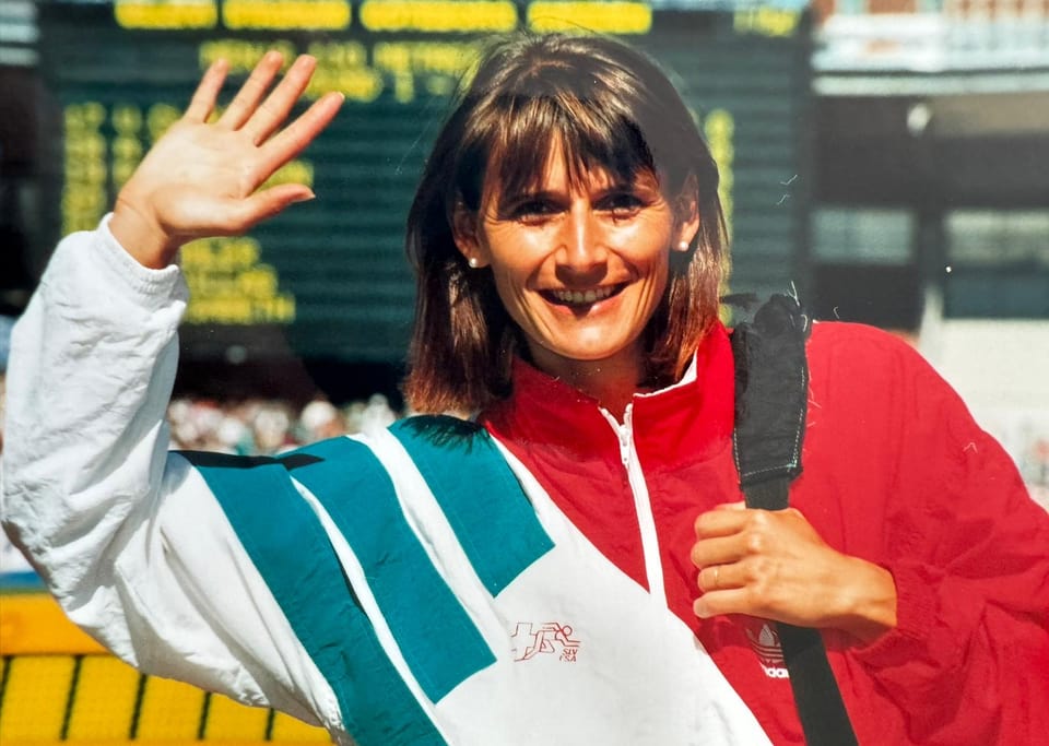 Sportlerin im Trainingsanzug winkt.