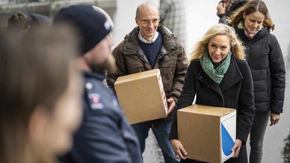 Drei Leute halten Kartonkisten mit den Unterschiftsbögen