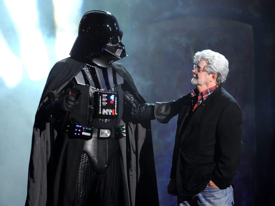 Darth Vader und ein Mann mit Bart stehen nebeneinander.
