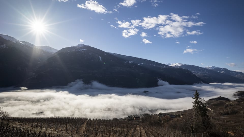 Landschaft mit Bergen, Wolken und Sonnenschein.