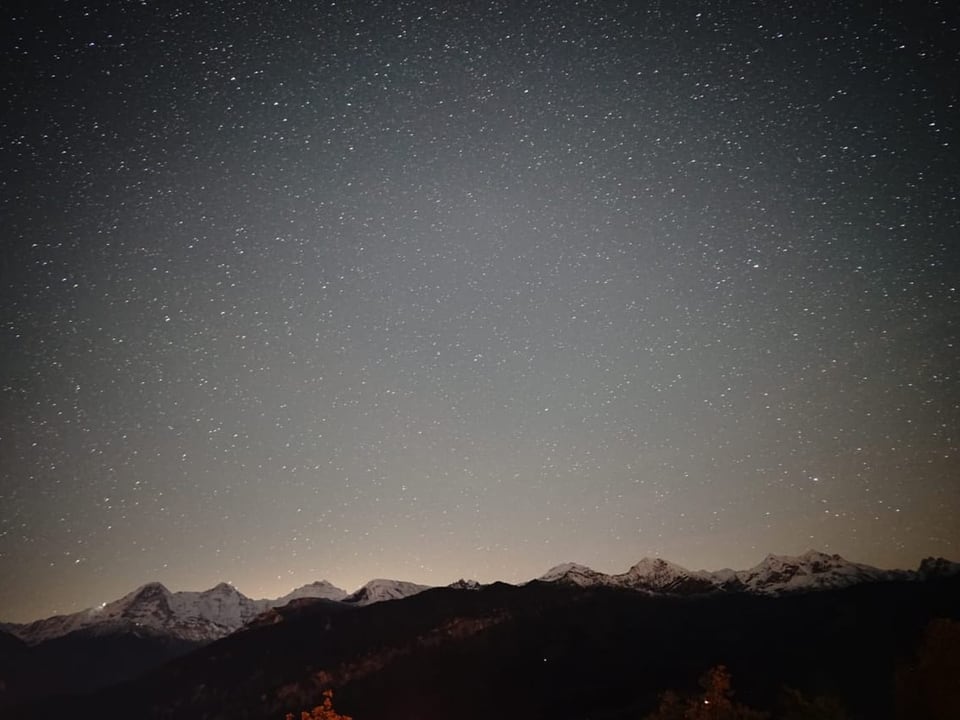 Sternenhimmel über verschneiten Bergen.