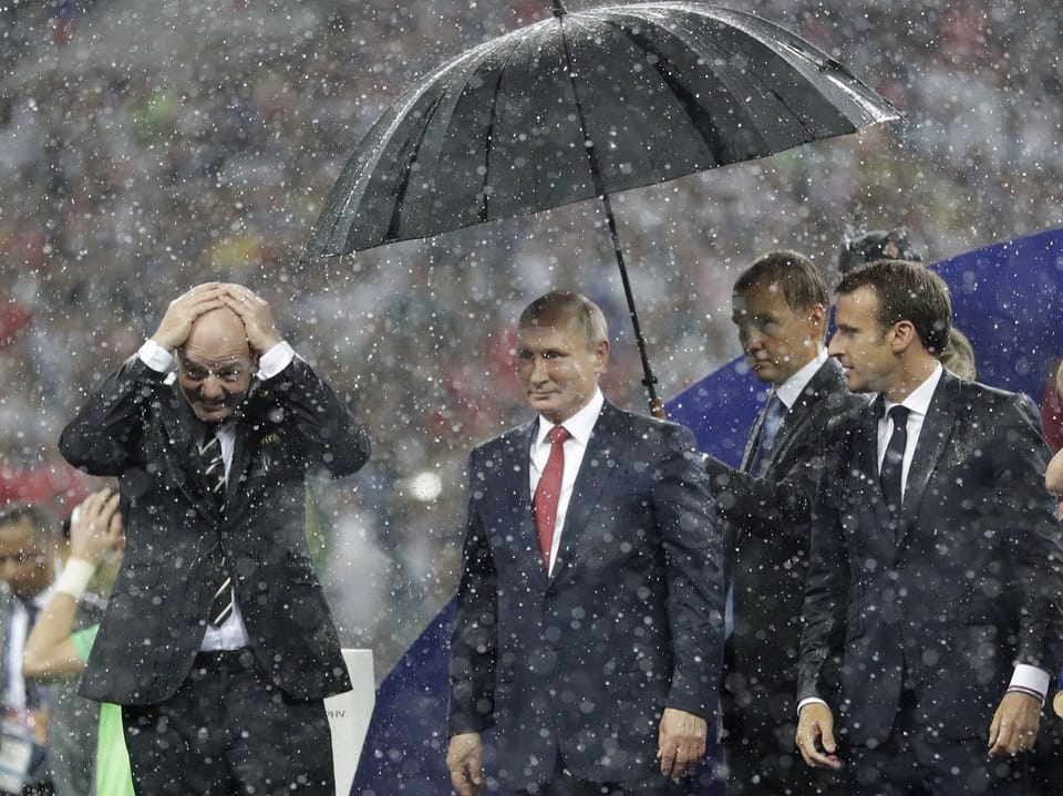 Fifa-Präsident Infantino, Putin und Macron im Regen in Moskau.