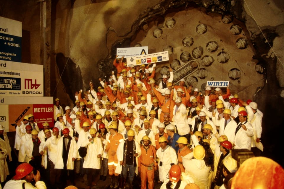 Gruppe von Arbeitern vor Tunnelbohrmaschine in Feierlaune.