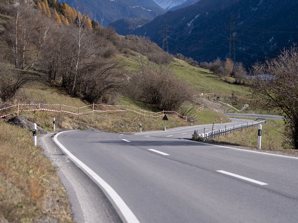 Kurvige Bergstrasse mit Bäumen und sanften Hügeln.