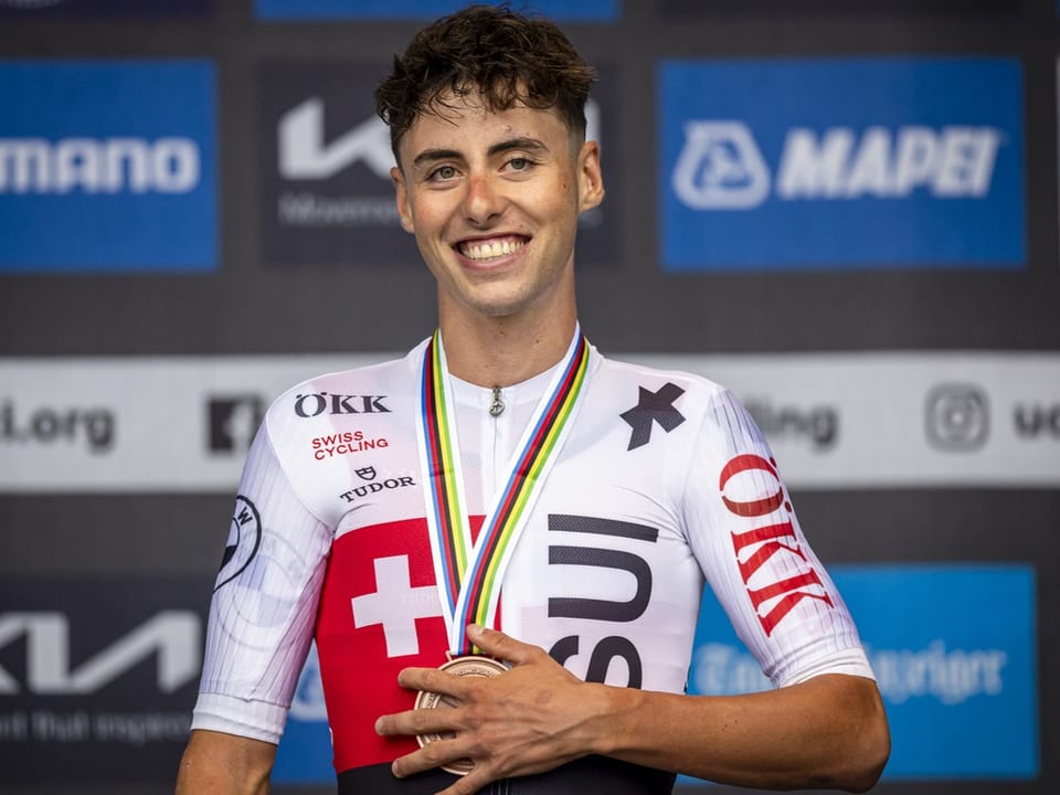 Siegreicher Radfahrer mit Medaille und Schweizer Trikot.