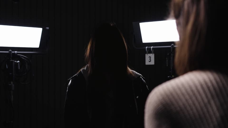 Eine anonyme junge Frau sitzt im Studio während des Interviews.