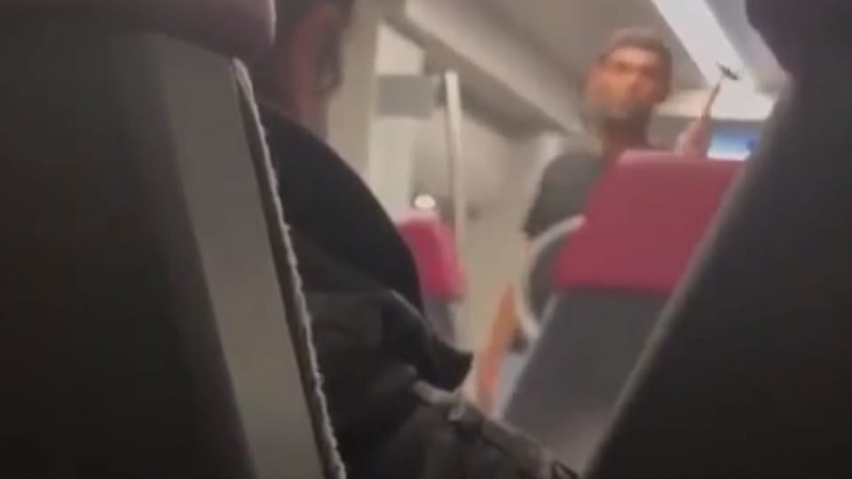 Ein verschwommenes Bild aus dem Zug, auf dem die Umrisse einer Geisel sowie der Täter mit dem Hammer zu sehen ist.