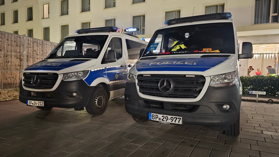 Zwei Polizeifahrzeuge stehen.