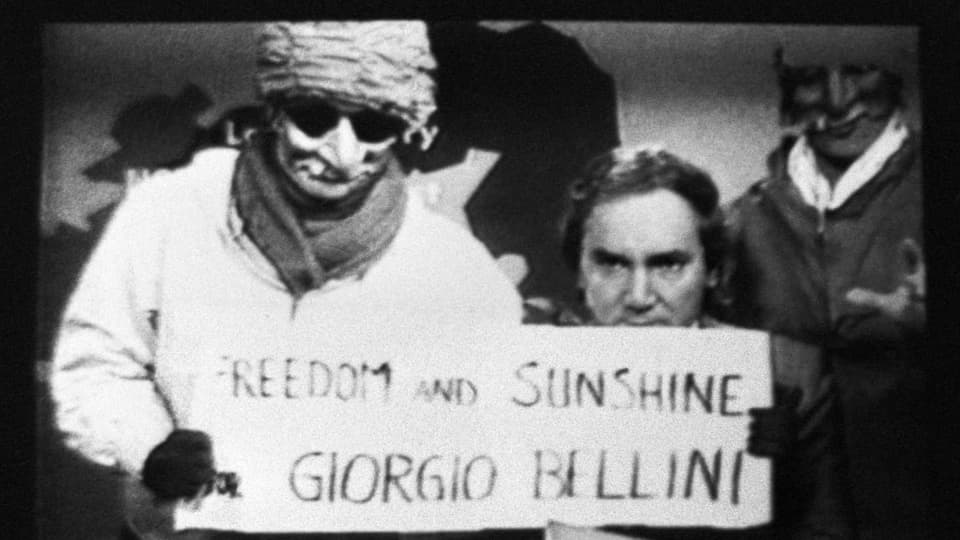 Vermummter hält Protestschriftzug «Freedom and sunshine for Giorgio Bellini» ins Bild