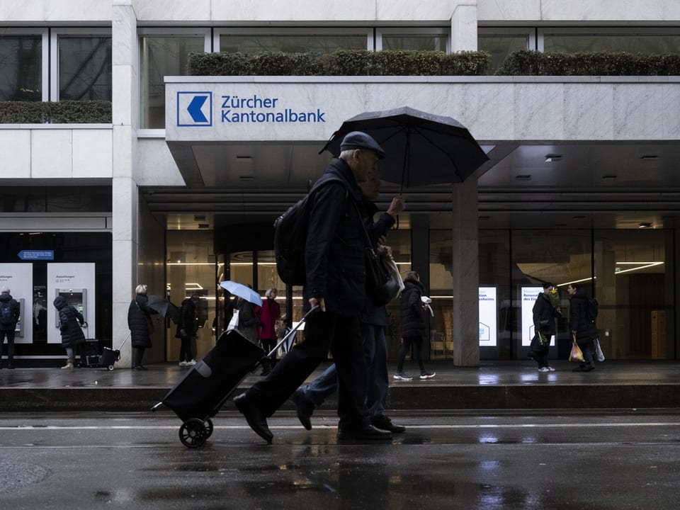 Menschen mit Regenschirmen vor der Zürcher Kantonalbank.