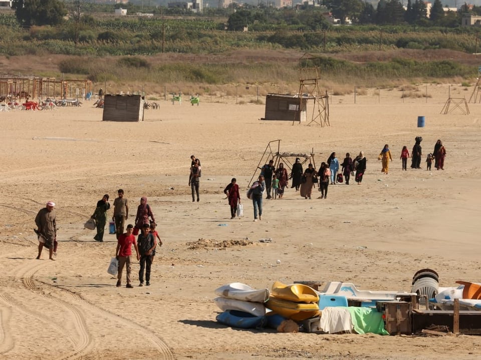 Gruppe von Menschen auf einem sandigen Strand.