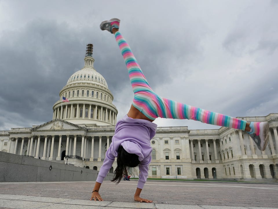 Ein Mädchen schlägt ein Rad ovr dem US-Kapitol.
