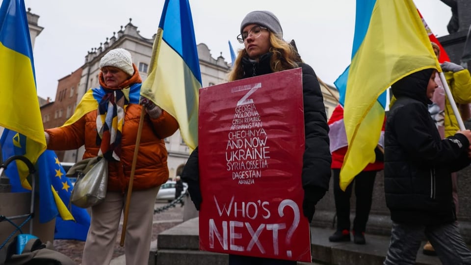 Protestierende gegen den Ukraine-Konflikt mit Schild um den Hals