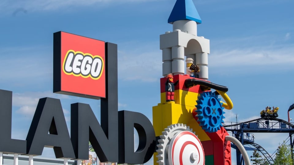 Neben dem Logo am Eingang zum Legoland ist eine Achterbahn zu sehen. 