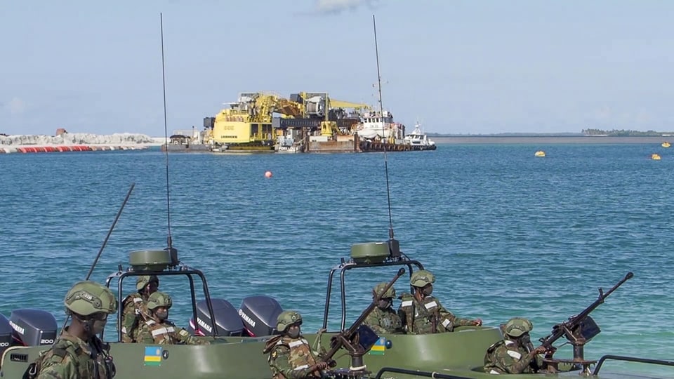 Rwandische Truppen fahren mit Booten durch einen Hafen in Cabo Delgado, Moçambique.