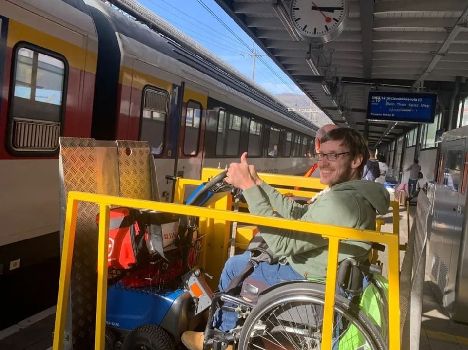 Ein Rollstuhlfahrer wird mit einem Lift auf Höhe des Einstiegs gehoben.