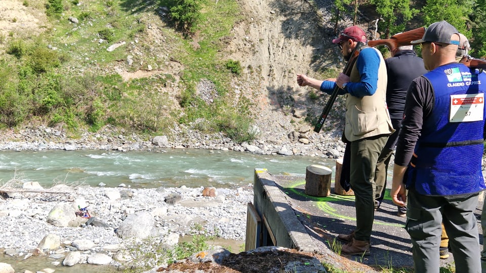 Die Schützen stehen auf einem Absatz hoch über dem blauen Fluss.