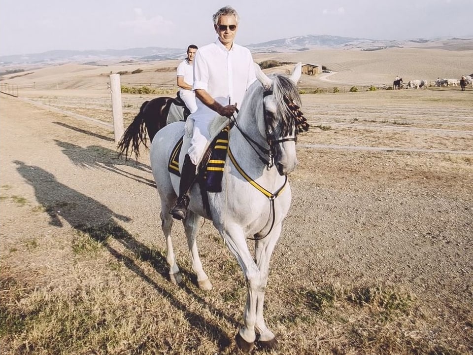 Andrea Bocelli auf einem weissen Pferd.
