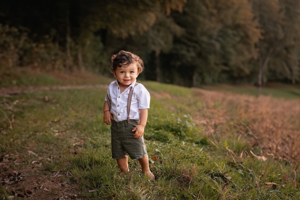 Rätoromanische Kindernamen: ein Kleindkind mit kurzen Hosen und weissem Hemd auf dem Feld