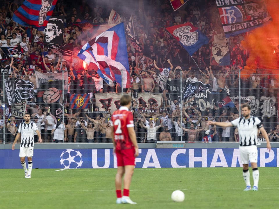 Fussballspiel mit Fans im Hintergrund und UEFA Champions League Banner.