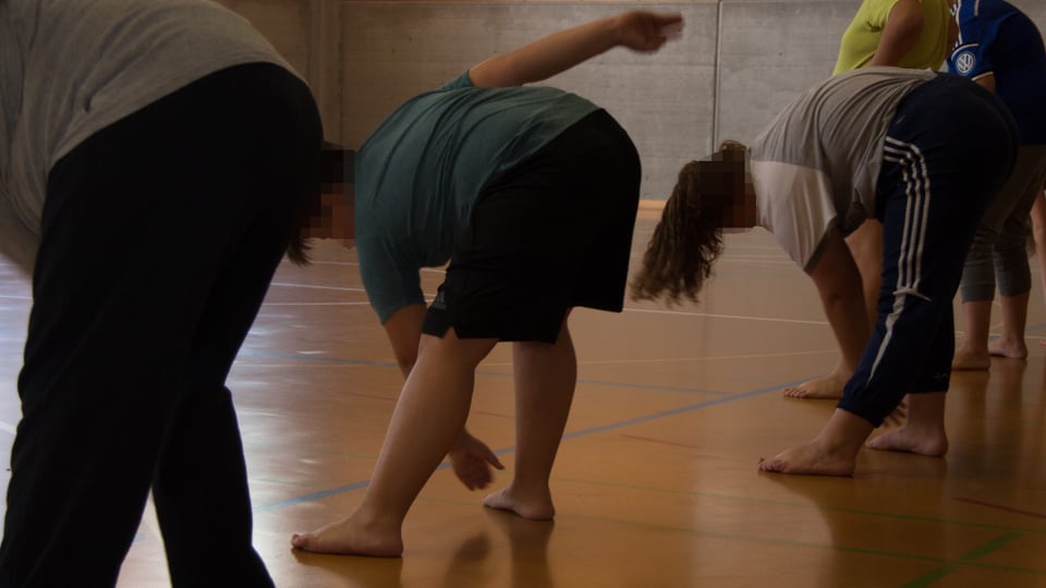 Die Teilnehmer machen Übungen in einer Turnhalle.