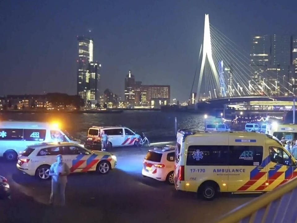 Krankenwagen und Polizeiautos bei Nacht vor der Erasmusbrücke in Rotterdam.