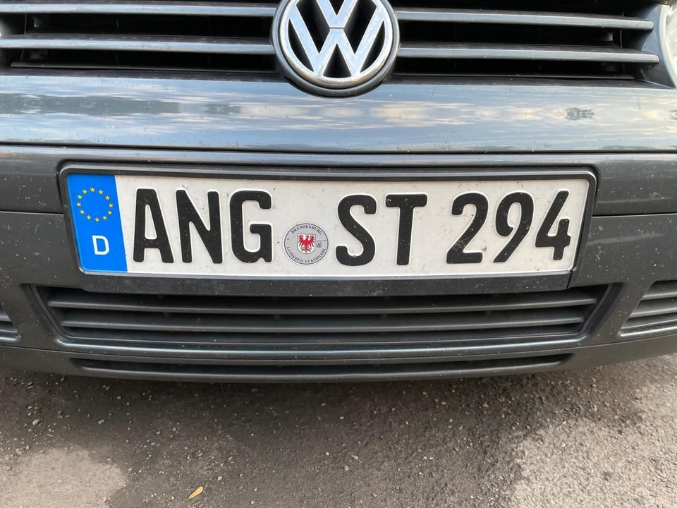 Nahaufnahme eines deutschen Kfz-Kennzeichens an einem grauen VW.