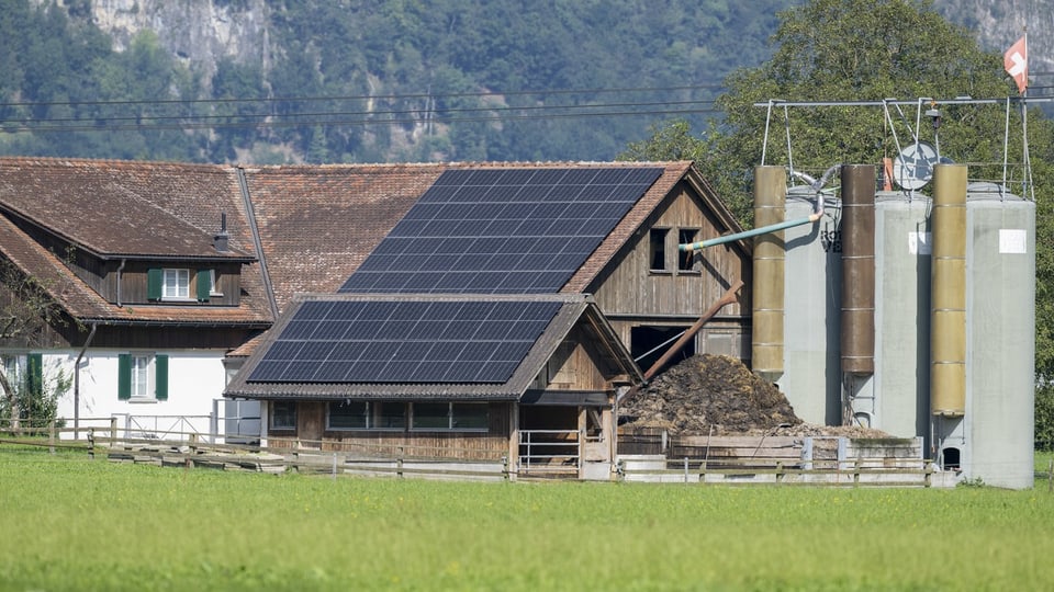 Ein Bauernhof mit Solarzellen auf dem Dach.