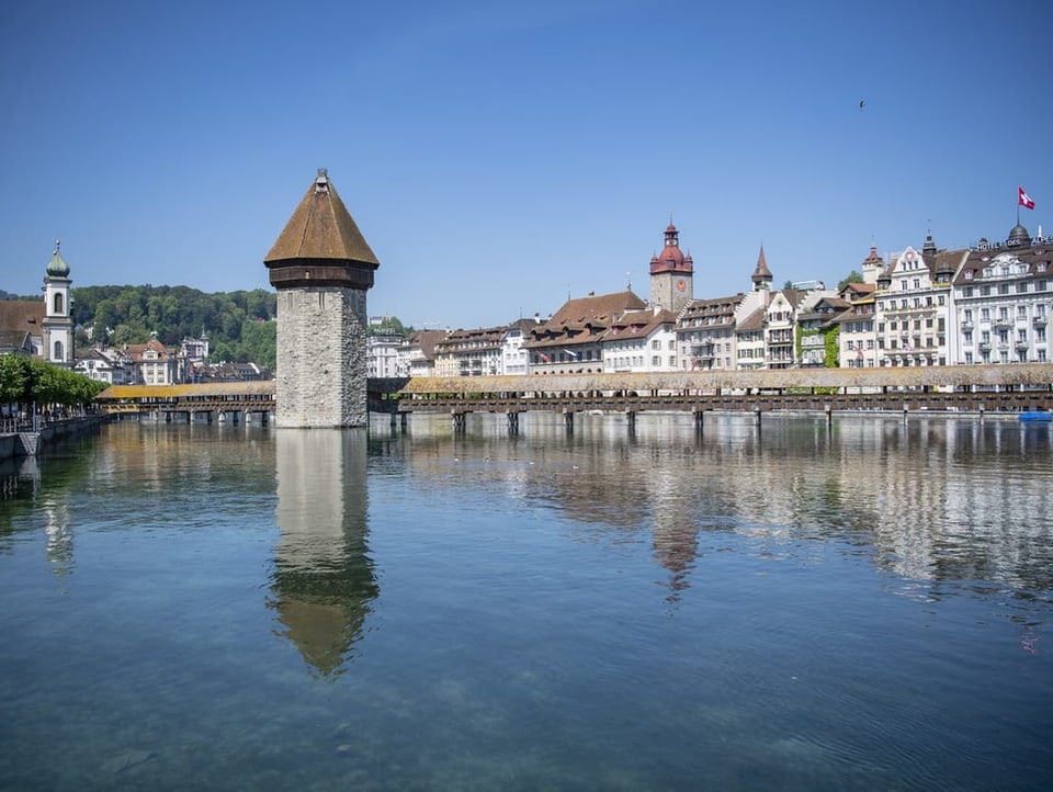 Kapellbrücke Luzern spiegelt sich im Wasser, im Hintergrund die Altstadt