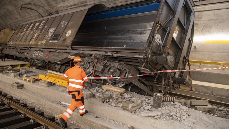 Ein Arbeiter geht auf den entgleisten Güterzug im Gotthard-Basistunnel zu.
