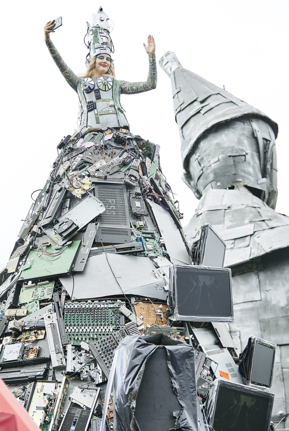 Eine Person in einem Kostüm, das aus vielen elektronischen Teilen zusammengestellt ist.
