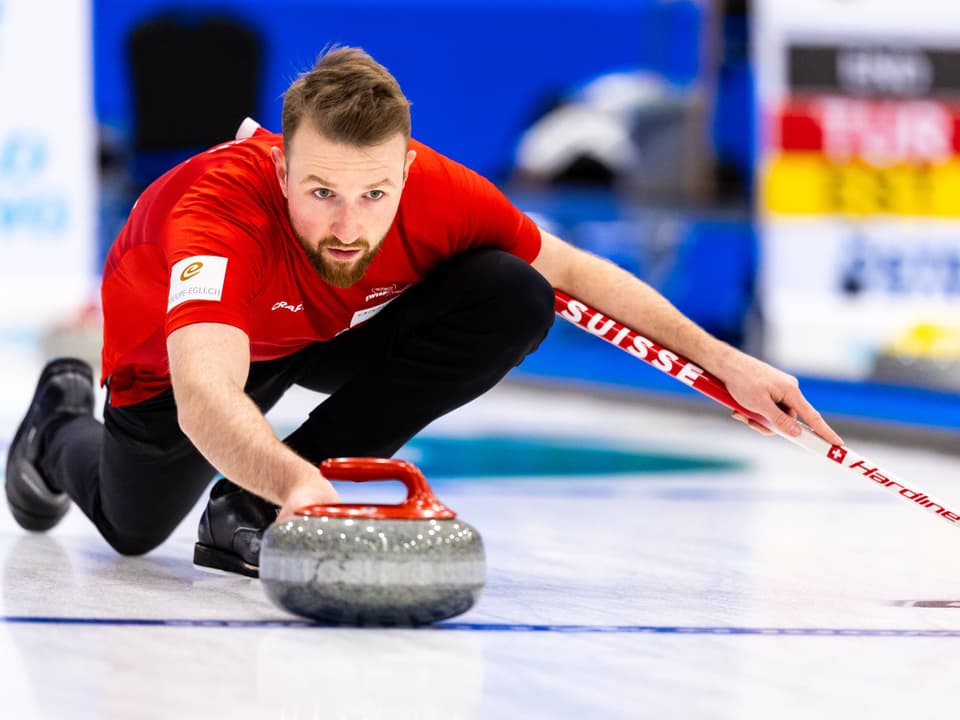 Mann in rotem Hemd beim Curling-Spiel.