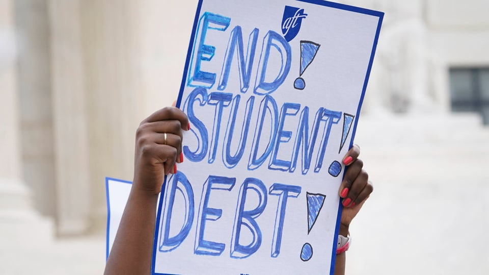 Person hält Plakat mit der Aufschrift «End Student Debt» in die Höhe