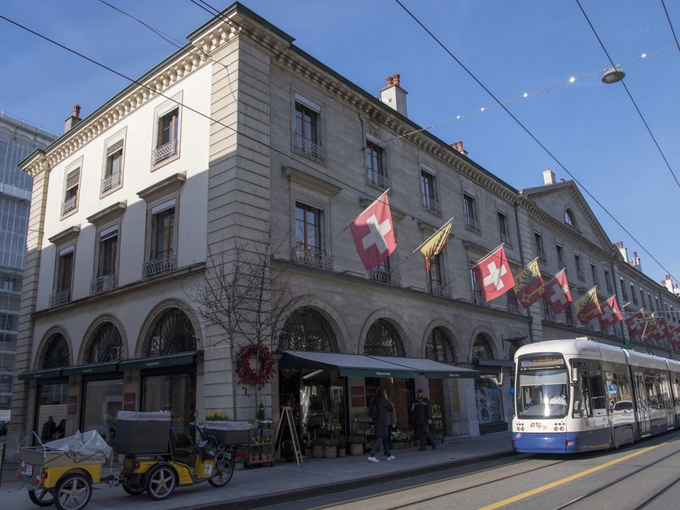 Strassenszene in Zürich mit Tram und Gebäude mit Schweizer Fahnen.