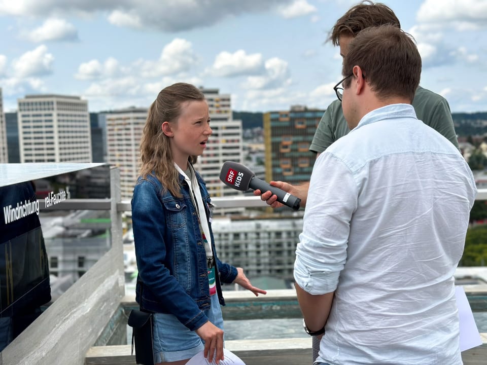 Eine Kinderreporterin stellt einem Mann Fragen.