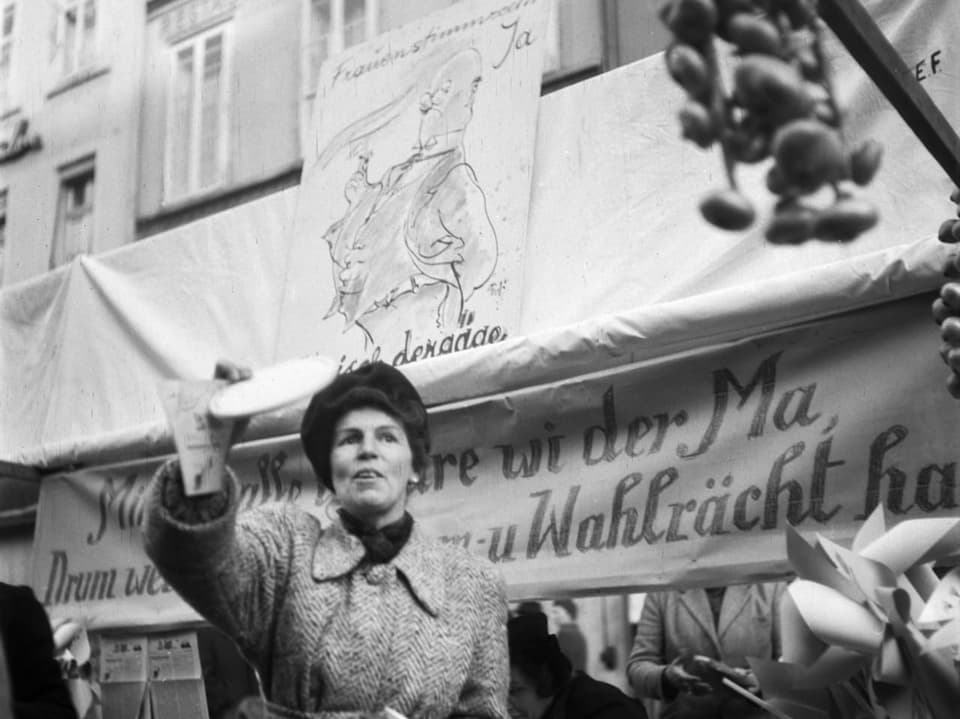 Frau verteilt Flyer bei einer Wahlkampagne auf dem Markt.