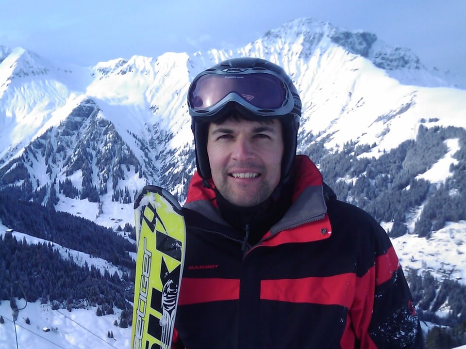 Marc Jost mit Skis in den Bergen.