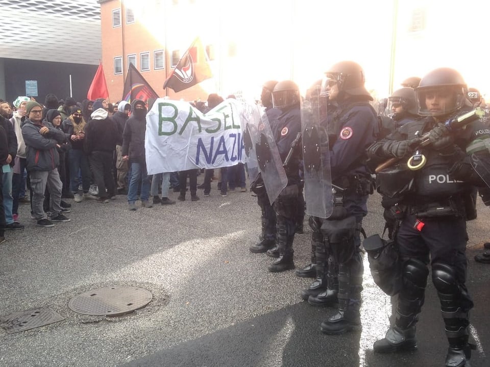 Links Demonstrant:innen stehen einem Kordon Polizisten gegenüber.