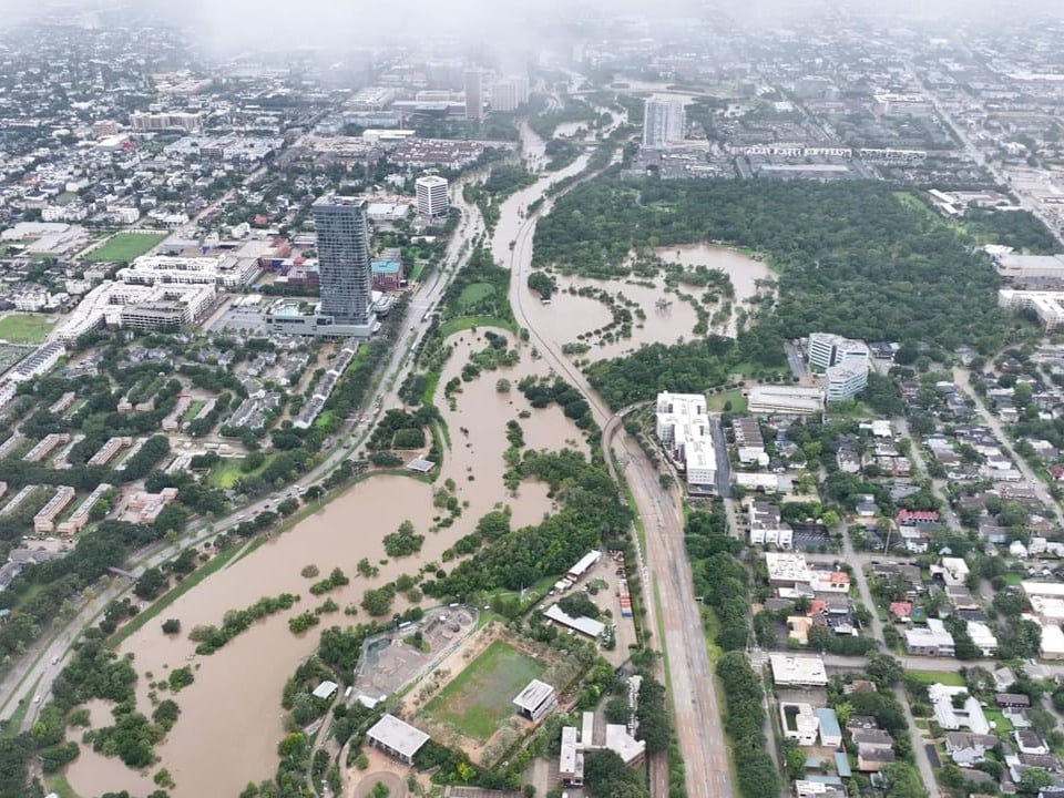 Luftaufnahme einer Stadt mit überflutetem Fluss.