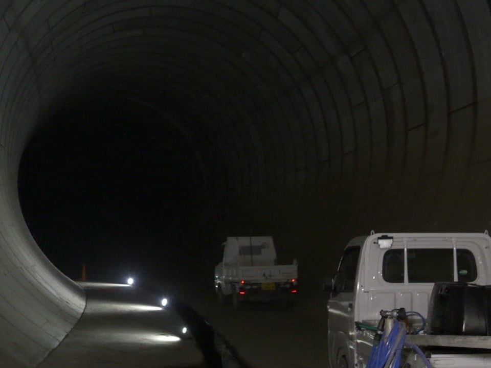 Lastwagen fahren durch die Entlastungstunnel