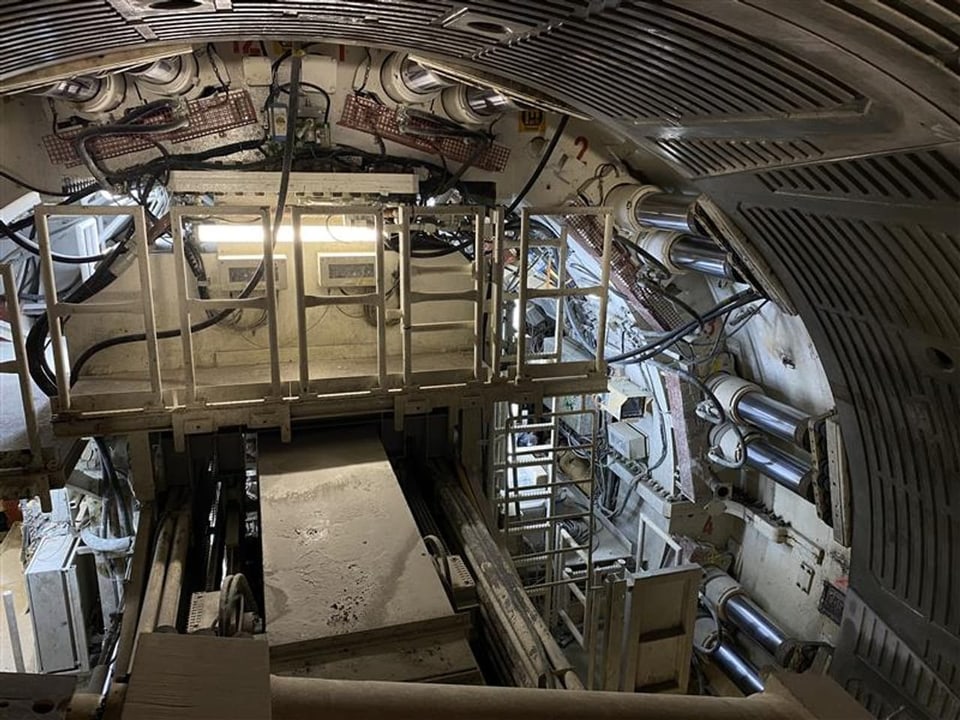 Innenansicht einer Tunnelbohrmaschine mit Licht und Metallstrukturen.