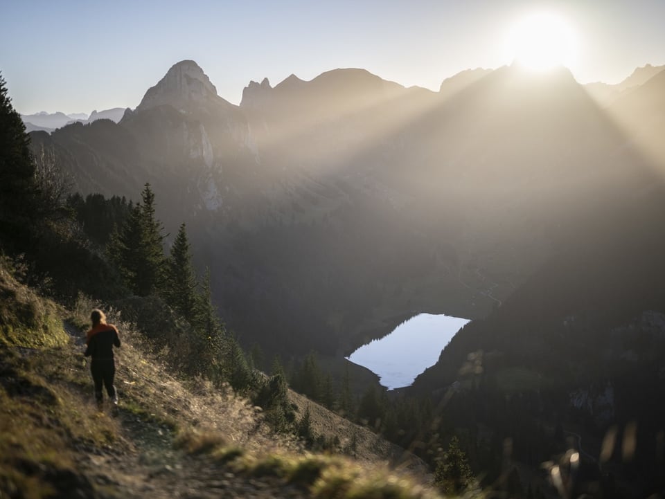 Bergsee mit Frau die auf dem Weg geht