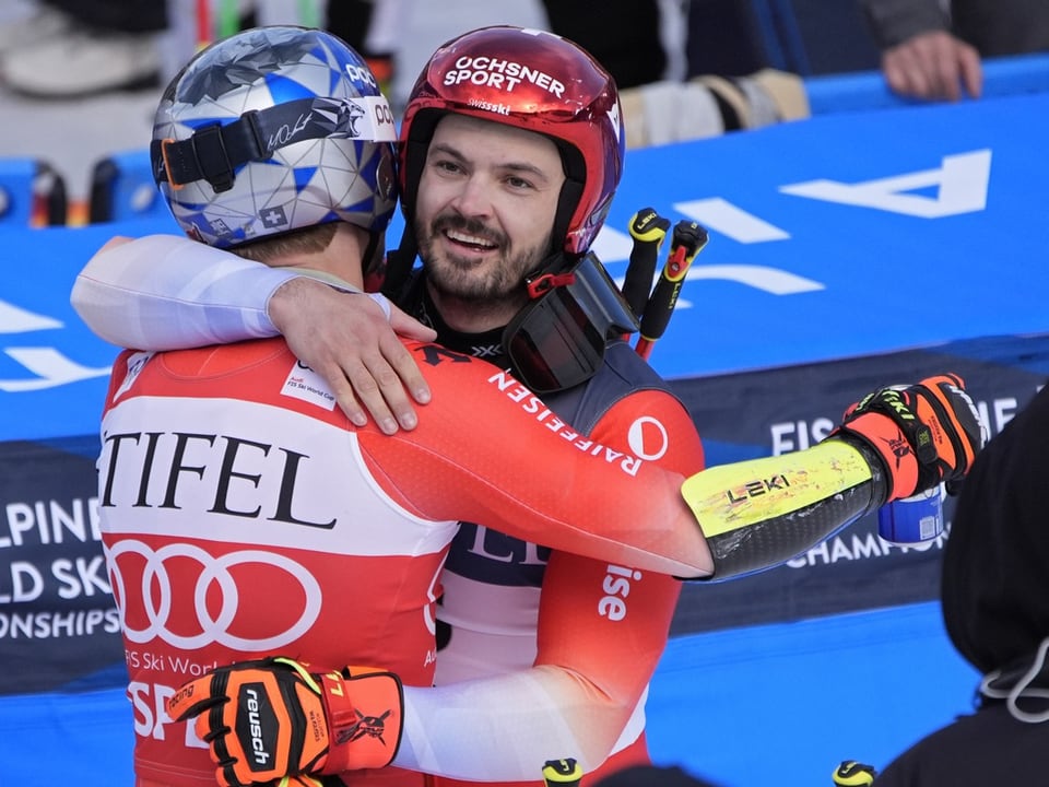 Zwei Skifahrer umarmen sich nach einem Rennen.