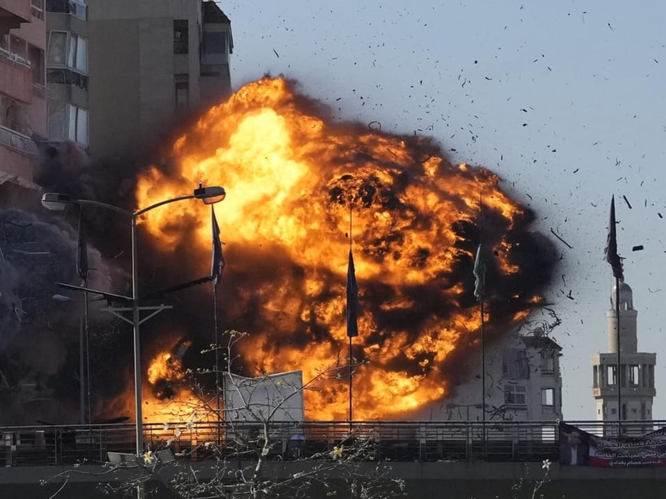 Grosse Explosion mit Feuerball vor einem Gebäude.