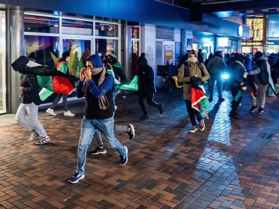 Menschen demonstrieren auf einem Gehweg in der Stadt bei Nacht.