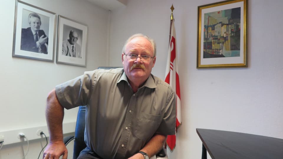 Portrait Pierre-André Comte, Sekretär des Mouvement autonomiste jurassien, vor Juraflagge.