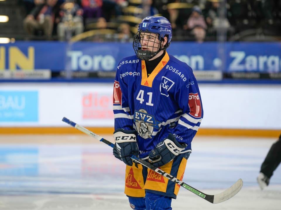 Eishockeyspieler in blauer Ausrüstung auf dem Eisplatz.