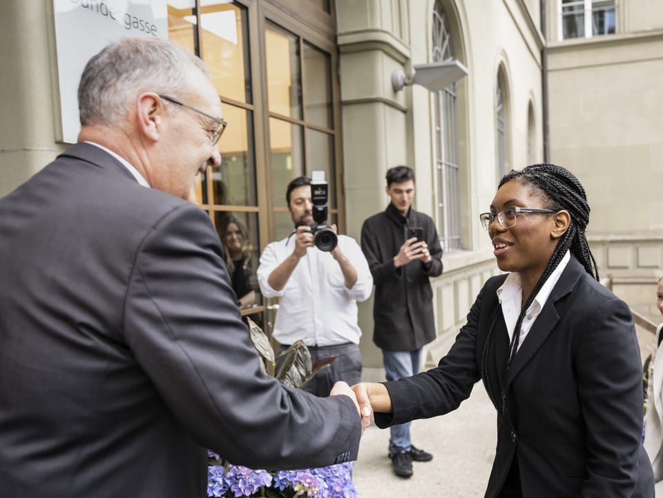 Guy Parmelin (links) gibt Kemi Badenoch (rechts) die Hand vor einem Gebäude in Bern.