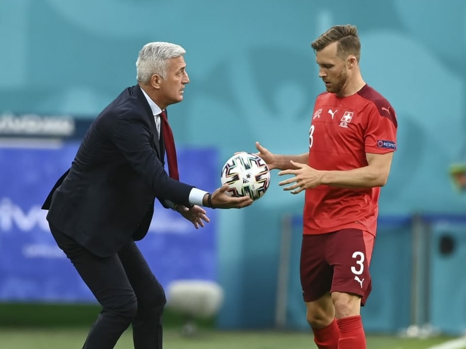 Nati-Trainer Vladimir Petkovic reicht Silvan Widmer an der Seitenlinie den Ball.